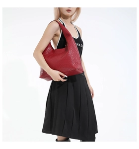Detail of red woven leather hobo bag showing texture and oversized crescent shape