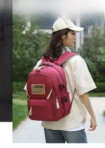 Detail view of burgundy waterproof oxford backpack with adjustable side buckles for travel