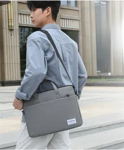 Detail of grey waterproof laptop bag with handle and fashion label in urban setting