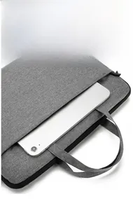 Detail of grey laptop bag showing front zipper pocket and reinforced carrying handle