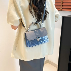 Sac bandoulière gris bleu avec panneau en PVC transparent et design matelassé sur un mannequin