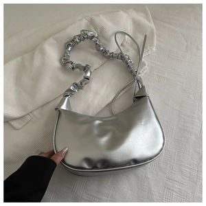 Detailed macro view of the silver metallic pleated bag featuring a unique knotted strap