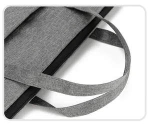 Close-up of the reinforced widened handle and smooth zipper on the gray laptop bag