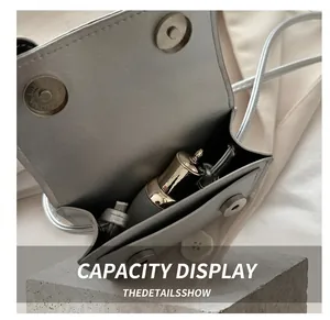 Detail showing the internal capacity and silver leather texture of a mini crossbody bag