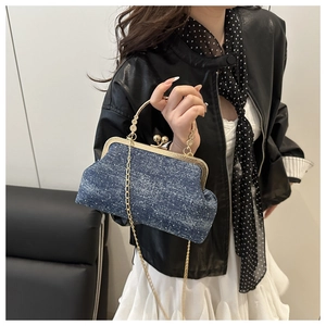 Close-up of vintage denim evening bag with gold floral handle and metal frame