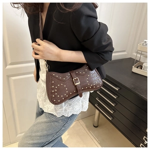 Vue détaillée du sac marron motif crocodile avec clous dorés et boucle en métal