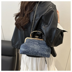 Retro denim frame bag with gold chain strap shown on a model in a lifestyle setting