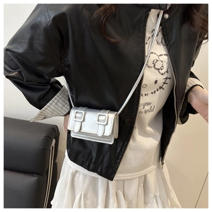 Detail showing the mini silver crossbody bag worn by a model to display size and scale