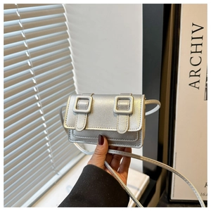 Close-up of silver mini crossbody bag with double buckles and metallic PU leather