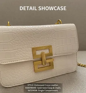 Detail of white crocodile embossed leather bag with gold buckle and chain strap
