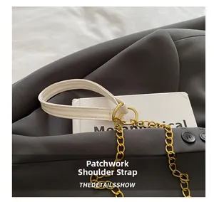 Detail of white crocodile pattern strap with elegant gold metal chain and stitching