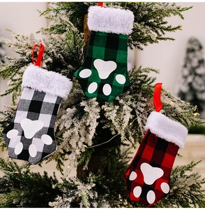 Plaid Christmas stockings with cat paw patterns hanging on a snowy Christmas tree