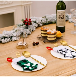 Macro view of Christmas cat paw cutlery holders with festive plaid patterns and fur trim