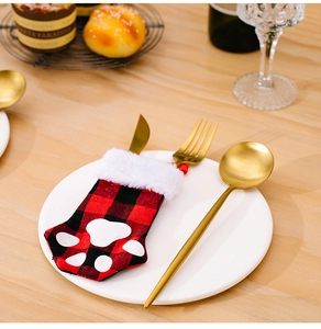 Close-up of red plaid cat paw cutlery holder with golden knife and fork on a plate