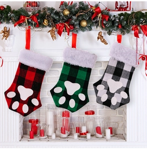 Lot de trois chaussettes de Noël à carreaux avec empreintes de pattes sur la cheminée