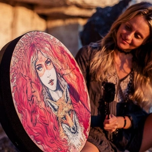 Artistic shamanic drum with red-haired girl and fox illustration held by a female model