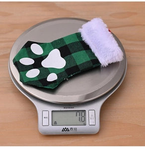 Détail d'une chaussette de Noël en patte de chat avec motif à carreaux verts et fourrure