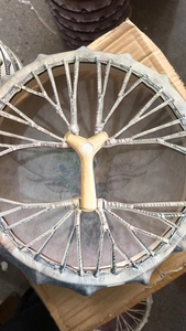 Detailed back view of a shamanic drum featuring a wooden Y-handle and tension ropes