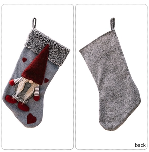 Detail of grey Christmas stockings featuring red gnome figures and heart patches