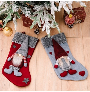 Detail of red and grey Christmas stockings with 3D forest gnomes on wood background