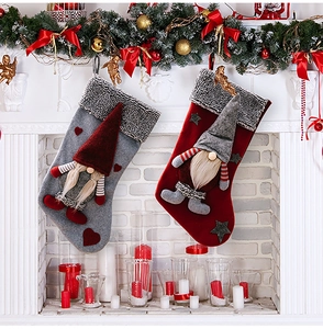 Detail view of 3D gnome Christmas stockings hanging on a festive decorated white fireplace