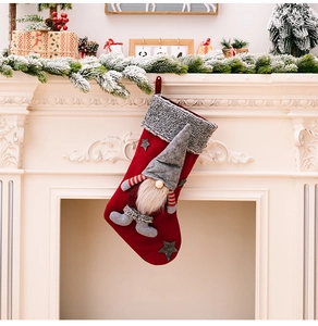 Detail of red Christmas stocking with a 3D gnome and grey faux fur trim by a white fireplace