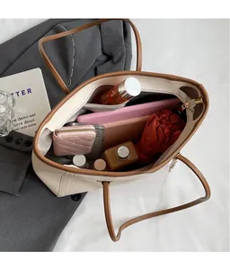 Top view of spacious beige and brown tote bag interior with umbrella and daily essentials