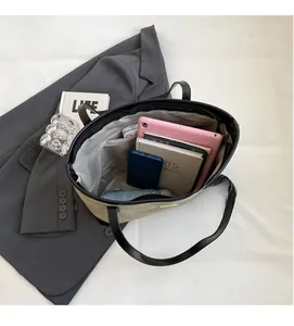 Spacious interior of beige suede tote bag holding a tablet, books, and a folding umbrella