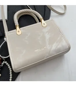 Top view of cream handbag with marble texture, woven handle and gold hardware details