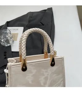Close-up of marble pattern handbag with woven handle and gold metal hardware