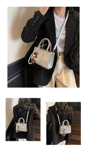 Detail of silver marble-pattern handbag with pearl charm and metallic round handles