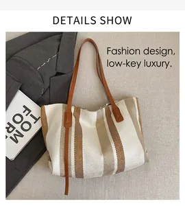 Detailed close-up of a striped woven tote bag with brown leather handles on a grey blazer