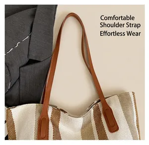 Detail of soft brown leather straps and striped woven fabric on a large tote bag