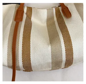 Detailed view of woven fabric texture with cream and brown vertical stripes on a tote bag