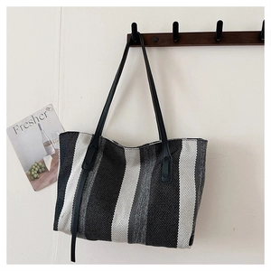 Close-up of vertical striped canvas tote bag with adjustable black shoulder straps