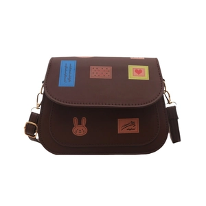 Bolso bandolera marrón oscuro con pegatinas retro y correa ajustable sobre fondo blanco