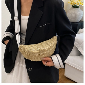 Detail of hand-woven beige straw half-moon crossbody bag with adjustable canvas strap