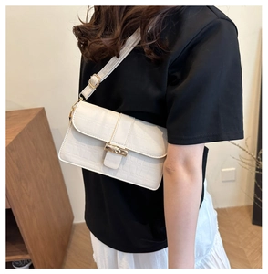 Detailed view of white crocodile pattern shoulder bag with a polished gold clasp