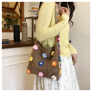 Détail d'un sac cabas au crochet avec fleurs 3D colorées et bandoulière granny square