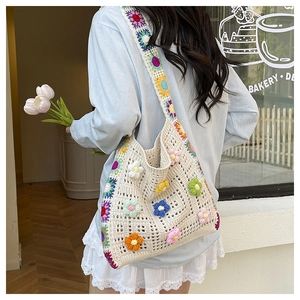 Détail d'un sac à bandoulière au crochet fait main avec des fleurs 3D colorées et texture ajourée