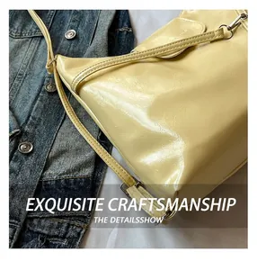 Close-up of butter yellow shoulder bag with fine faux leather texture and silver hardware