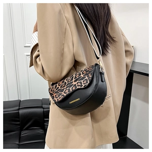 Detail of crossbody saddle bag with leopard print flap and striped shoulder strap