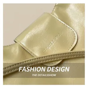 Detail of cream yellow matte faux leather bag with embossed logo and pleated texture