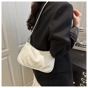 Sac lune blanc chic à motif crocodile porté avec un blazer noir par un mannequin