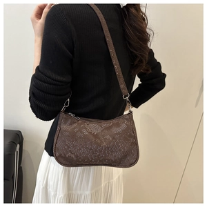 Détails du motif peau de serpent marron foncé et des boucles métalliques du sac vintage