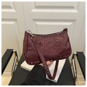 Détails de la texture lézard bordeaux brillant sur le sac à bandoulière chic