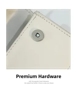 Close-up of a silver magnetic clasp on a beige leather mini crossbody bag for girls