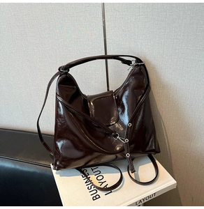 Close-up of glossy brown patent leather texture and metallic buckle on multifunctional bag