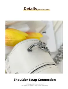 Detail of white leather shoulder bag with silver D-ring and metal chain strap connection