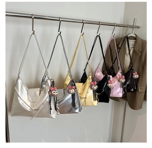 Detailed row of various colored hobo tote bags with plush bear charms on display
